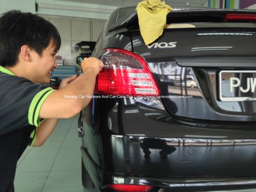 happy worker cutting the excess tint film on the Toyota Vios tail lamp